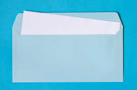 open blue envelope with  blank paper on blue backgroundの写真素材