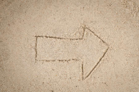 Close up to arrow drawing on sandの写真素材