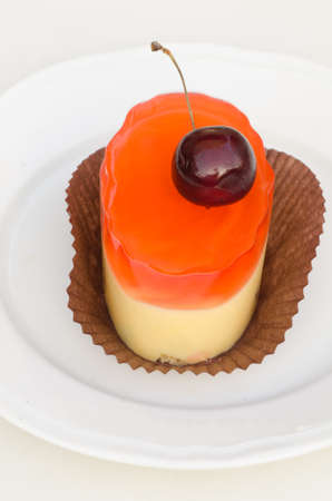 maracuya mouse with geatine and cherry on white plate