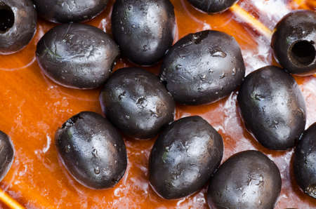 black olives on brown plateの写真素材