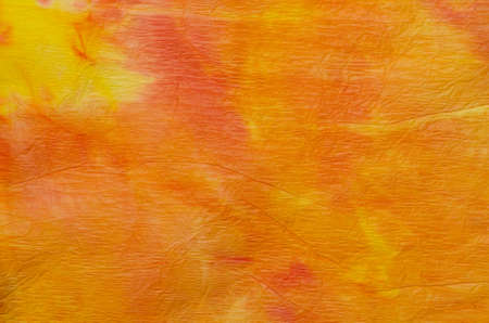 orange watercolor painting on crepe paper background textureの写真素材