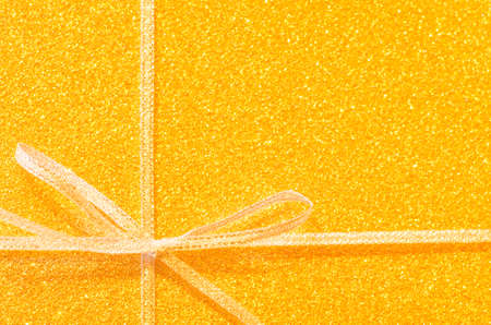 golden gift ribbon on glittering backgroundの写真素材