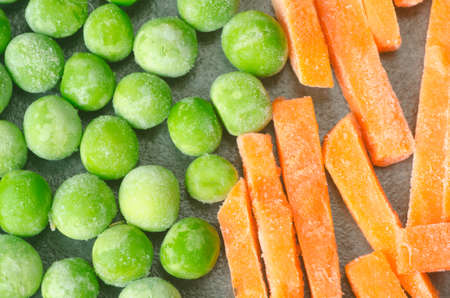 closeup to green frozen peas and carrotsの写真素材