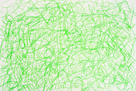 green crayon doodles on white paper backgroundの写真素材