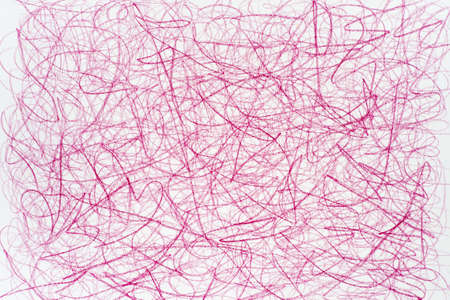 red crayon doodles on white paper backgroundの写真素材