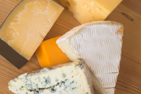 different types of cheese on wooden table