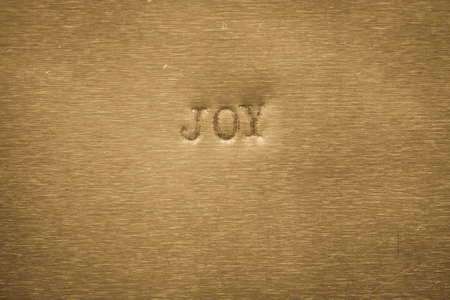 word joy printed on golden metallic backgroundの写真素材
