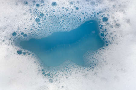 closeup to white foam on blue water