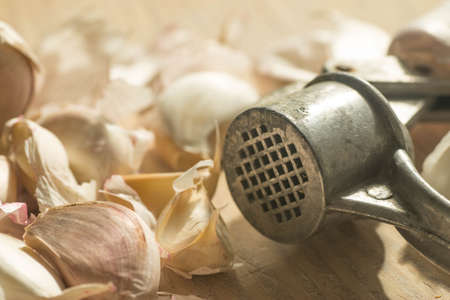 closeup to group of garlic cloves and garlic pressの写真素材