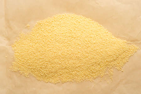 heap of dry couscous on brown paperの写真素材