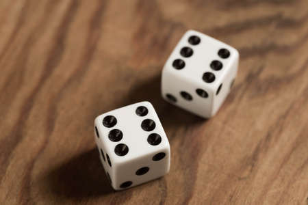 wite dices with number 6 o wooden table