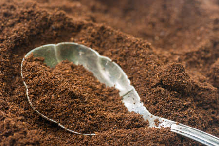 closeup to ground cofee in silver spoon