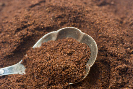 closeup to ground cofee in silver spoonの写真素材