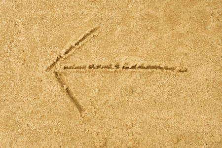 arrow sign drawing in sand background