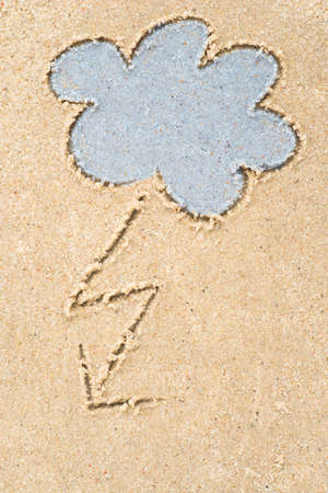 stormy clouds drawing in sand backgroundの写真素材