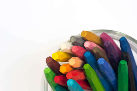 multicolored crayons in cup on white paperの写真素材