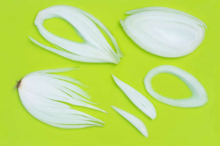 slices of onion on green plastic cutting board top view