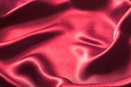 red wavy glossy silk textile texture background selective focusの写真素材