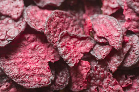 purple baked beet chips closeup on wooden backgroundの写真素材