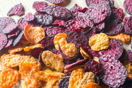 heap of baked carrot and beet  chips closeupの写真素材