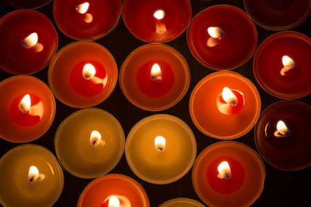 closeup to burning tealights in warm colorsの写真素材