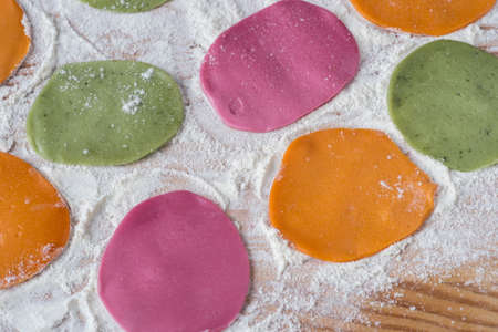 multicolored dyed pieces of raw for dumplings on tableの写真素材