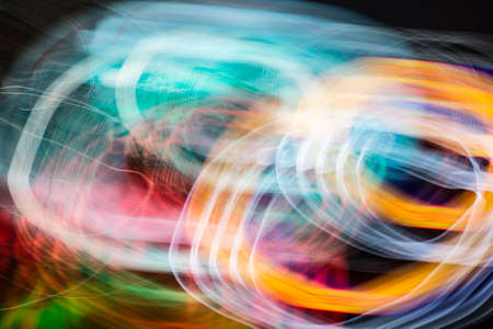 multicolored motion blurred lights in dark patternの写真素材