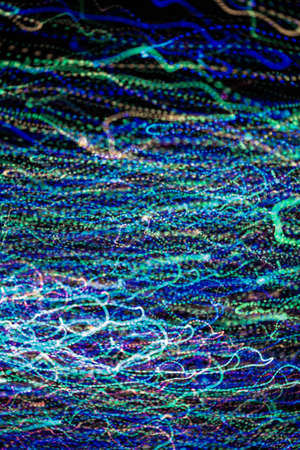 multicolored motion blurred lights in dark patternの写真素材