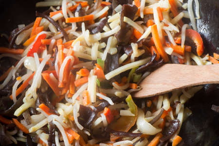 asian noodles with vegetables in wok closeupの写真素材