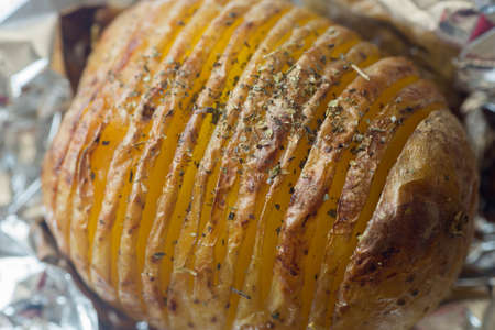 sliced baked in oven potatoes with herbsの写真素材