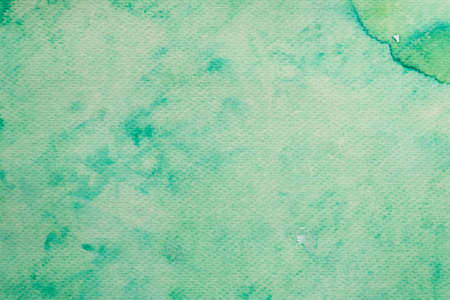 green watercolor color painted on paper background textureの写真素材
