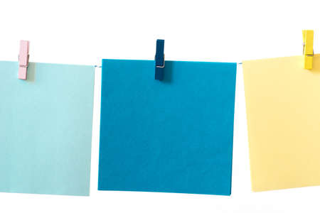 pieces of note paper pegged to a string on white background macro