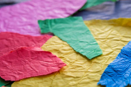 creased multicolored paper pieces macro  selective focus
