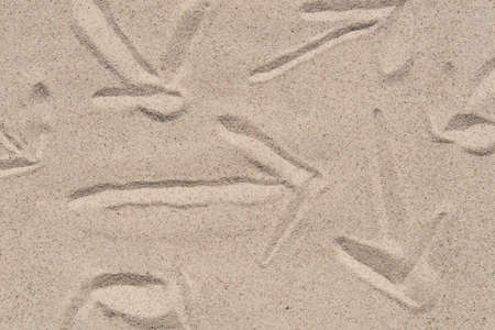 arrow sign on natural sand texture background closeup
