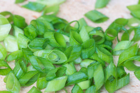 chopped fresh chives on cutting board closeuo selective focus