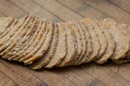 sliced tempeh on wooden cutting board closeup selective focus