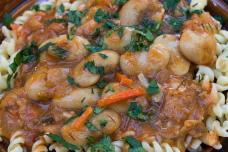 vegan dinner baked giant beans with vegetables on plateの写真素材