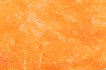 orange painted watercolor on paper background textureの写真素材