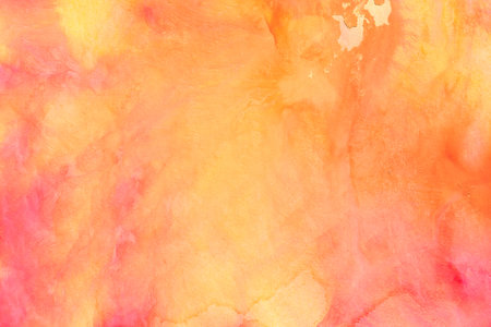orange painted watercolor background on paper textureの写真素材