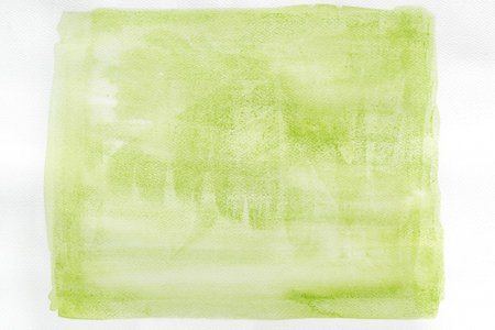 greenish painted watercolor background on white paper textureの写真素材