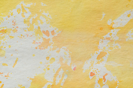 yellow and white watercolor painted background on paper textureの写真素材