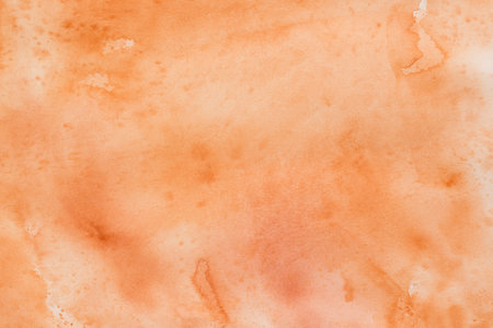 orange painted watercolor background on paper textureの写真素材