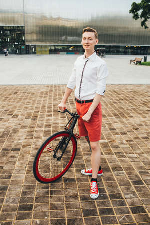 Hipster with red bycicle and tattoo on leg.の写真素材