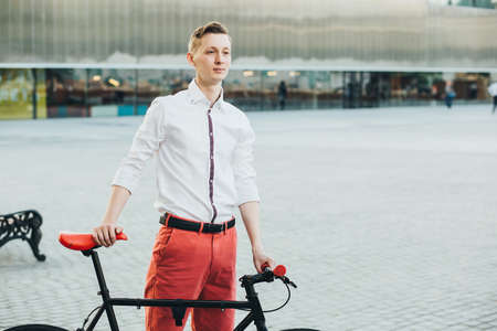 Hipster with red bycicle and tattoo on leg.