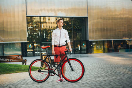 Hipster with red bycicle and tattoo on leg.の写真素材