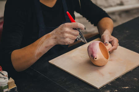 Female Potter creating pot and decor it