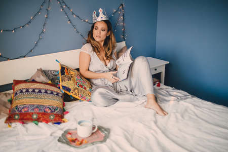 the girl with the crown lying on the bed in the house,