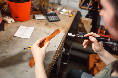 Close up of hands tanner performs work on table with toolsの写真素材
