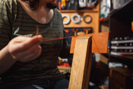 Close up of hands tanner performs work on table with tools