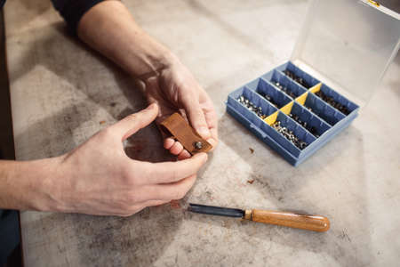 Close up of hands tanner performs work on table with toolsの写真素材
